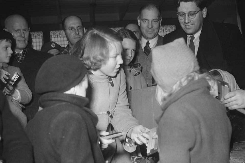 Prinses Beatrix deelt in 1953 speelgoed uit aan kinderen uit het rampgebied.