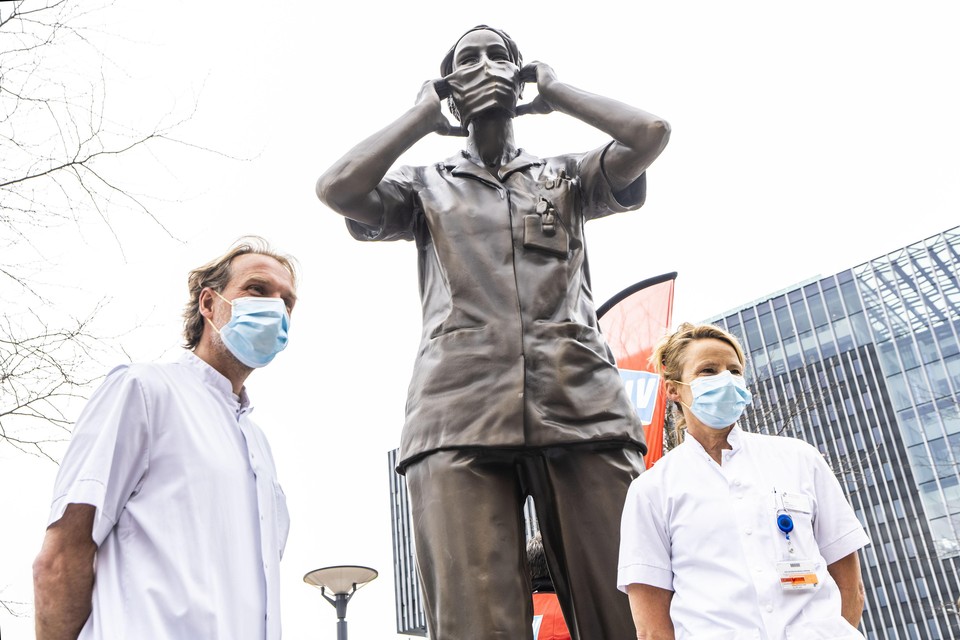 De ic-verpleegkundigen Bastiaan Velzel en Helen van Rijn met in hun midden het standbeeld van de Haagse verpleegkundige Aniek. Het standbeeld symboliseert de onmisbare beroepen zoals die van de zorgmedewerkers.