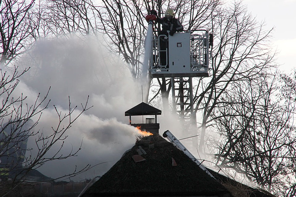 Grote brand in woning met rieten kap in Leimuiden. De vlammen slaan uit het dak. Foto Toon van der Poel