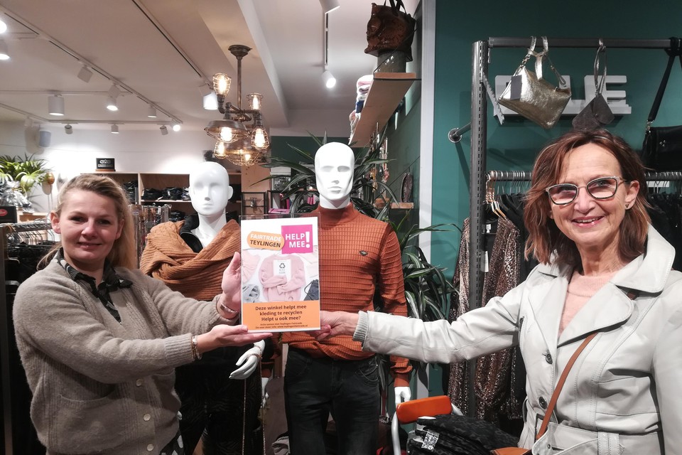 Monique Knops van Teylingen Fairtrade overhandigt Wendy van Kampen van Blue In informatiemateriaal over de actie om kleding te recyclen.