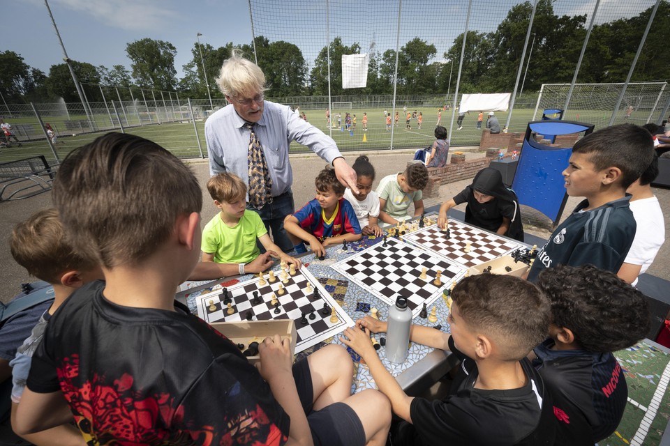 Naast het veld waar kinderen voetballen en rugbyen, krijgt een andere groep schaakles