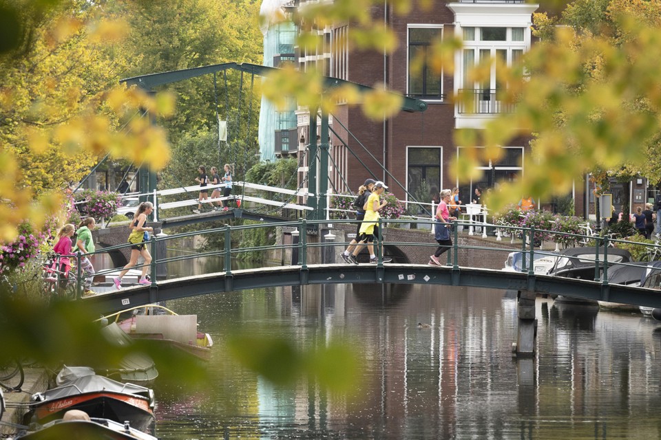 Deelnemers aan de 100 Bruggenloop steken de Oude Rijn over.