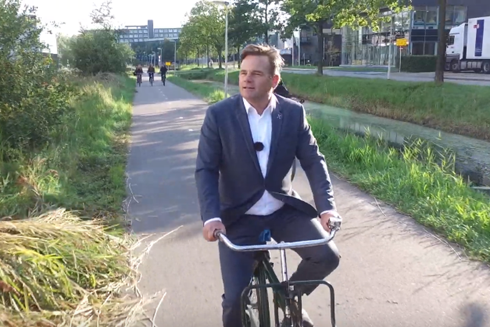 Promotiefilmpresentator en wethouder Paul Dirkse op de fiets over de Hartlijn.