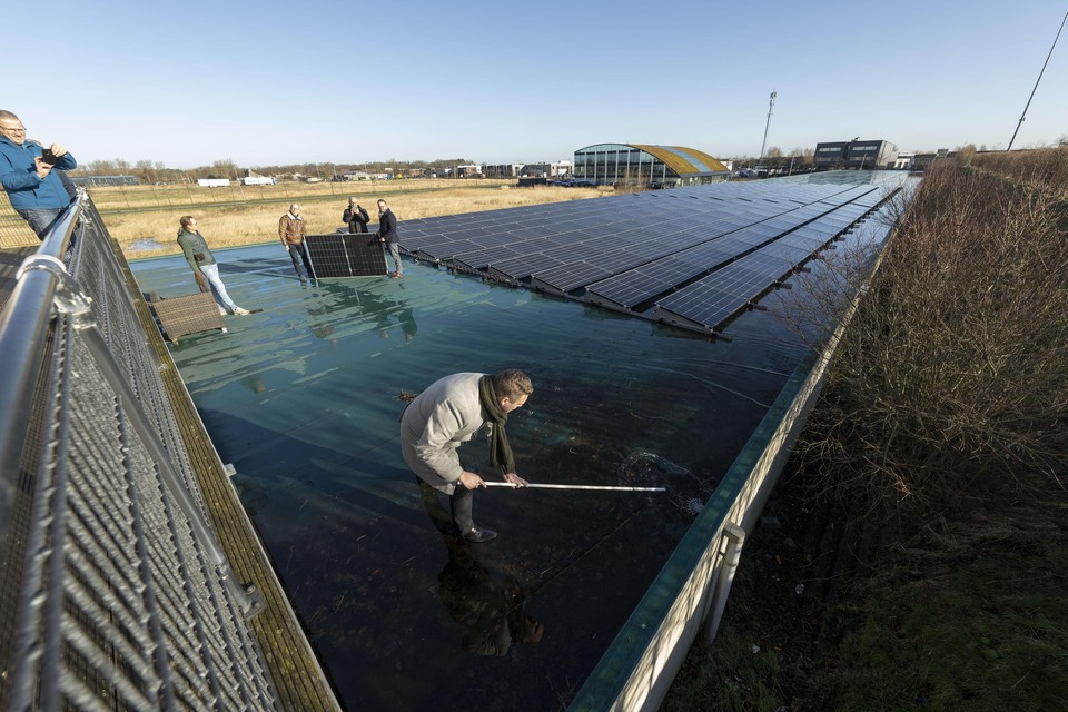 Wethouder Adger van Helden ontstopt de dakafvoer van Schietsportvereniging Katwijk, waar zonnepanelen voor de Katwijkse Energie Coöperatie komen te liggen.