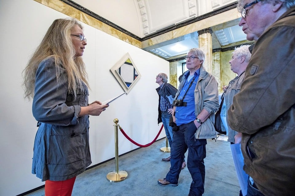 Marike Hoogduin staat klaar om vragen van bezoekers over het schilderij van  Theo van Doesburg te beantwoorden.