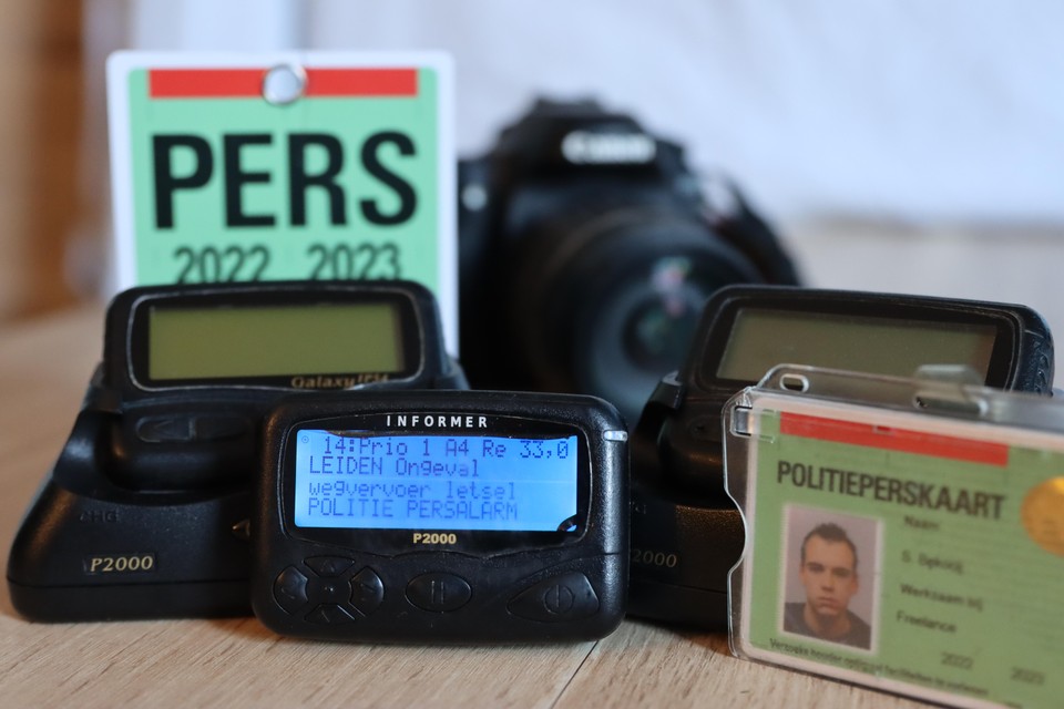 Piepers, perskaart en camera, het onmisbare gereedschap van de 112-fotograaf.