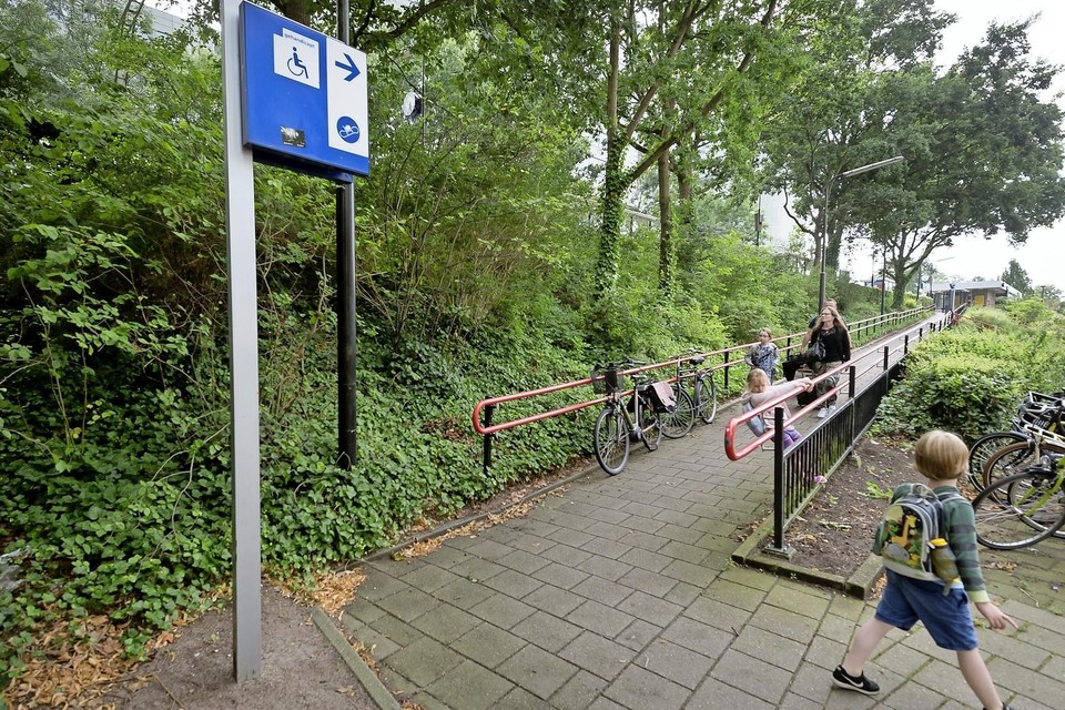 Volgens het blauwe bord is de helling bedoeld voor rolstoelen, maar een individuele beklimming blijft lastig bij station Leiden Lammenschans.