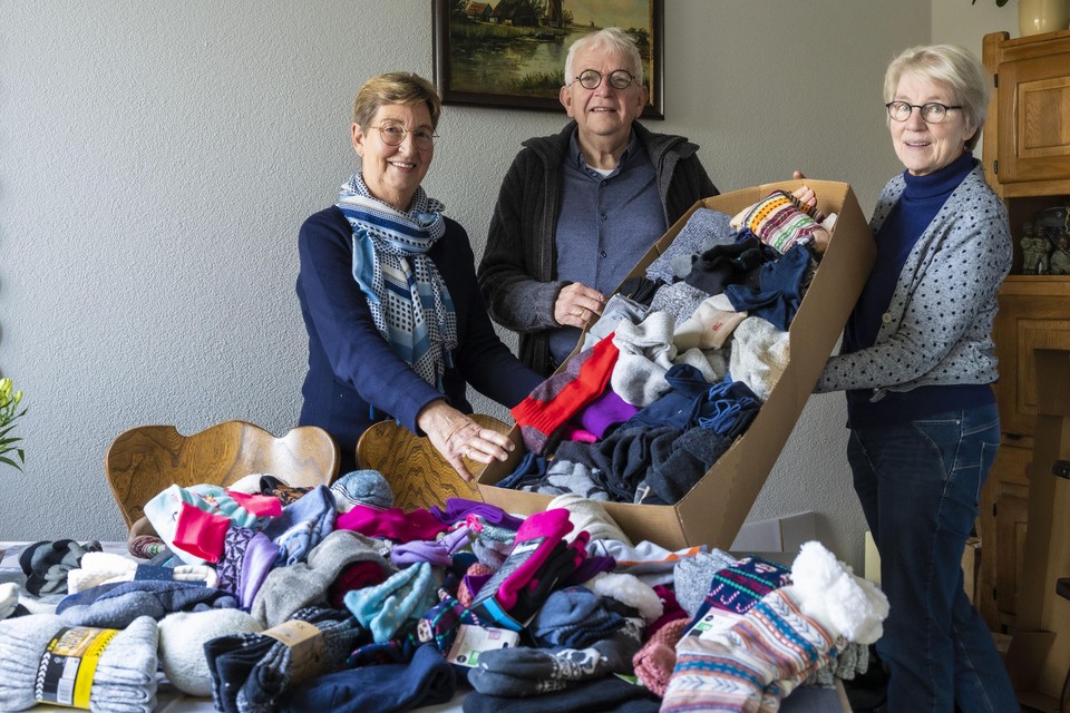Wilma van Delft en Jaap en Corry de Mooij met hun ingezamelde warme sokken.
