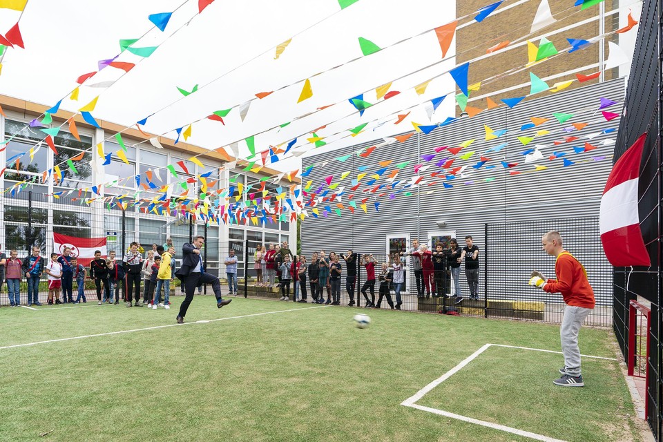Wethouder Paul Dirkse opent al schietend het pannaveldje van basisschool De Vlieger.