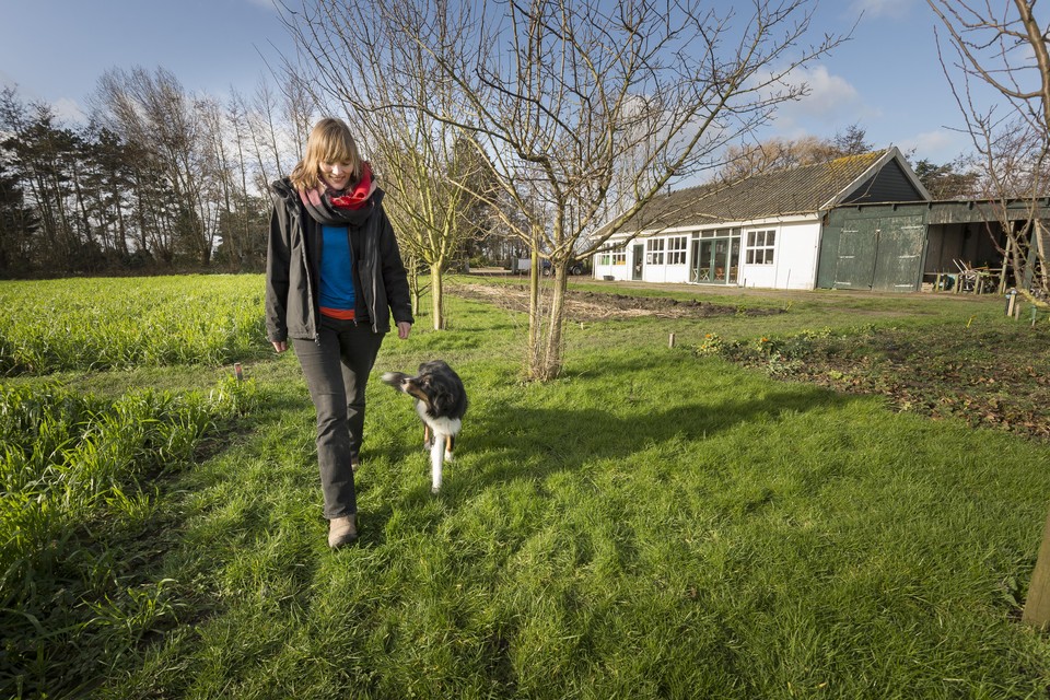 Mariska Verhulst, met hond Doris op het land van Bij Mei: ,,Ik wil de mensen het gevoel geven dat ze medeverantwoordelijk zijn, een klein beetje eigenaar van de plek.’’