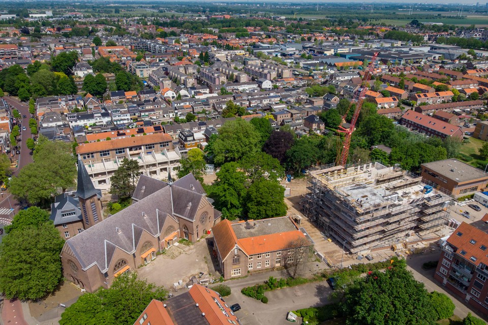 Het Jozefpark in Hillegom vanuit de lucht. De bouw van appartementenflat Crescendo (rechts) vordert. Ook in en naast de Jozefschool (midden links) gaat de bouw nu vlot. In het kerkelijk vastgoed blijft het nog stil.