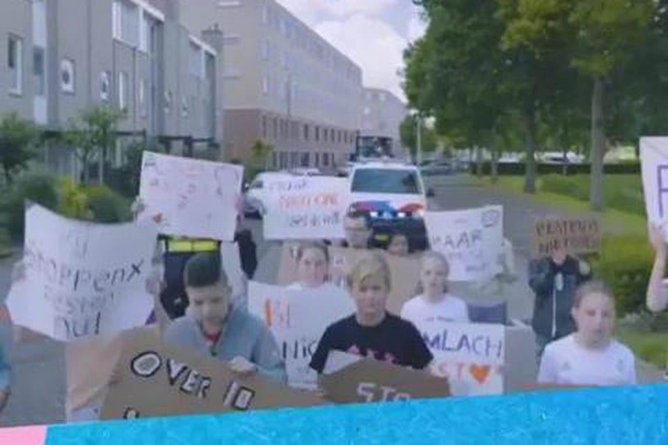Met spandoeken tuigen Alphense kinderen met anti-pestenspandoeken onder aanvoering van kinderburgemeester Safae Ahannay langs het Europapark.