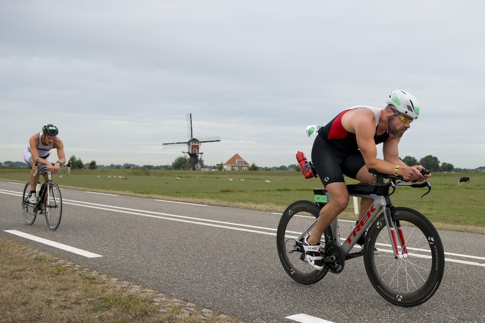 Deelnemers aan de triatlon van Leiderdorp rijden over de provinciale weg tussen Leiderdorp en Roelofarendsveen.