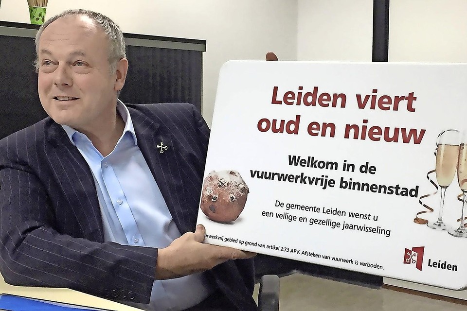 Burgemeester Henri Lenferink toont een nieuw bord.