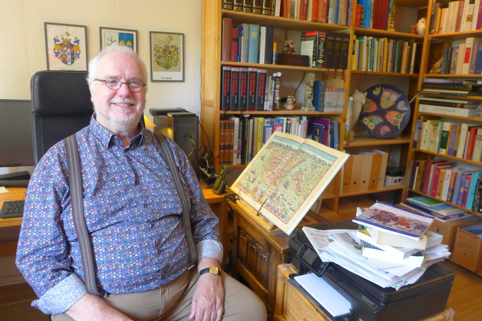 Paul Christiaan Smis temidden van planken vol boeken over de Middeleeuwen.