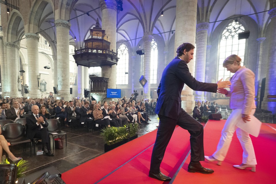 Annetje Ottow maakt het spreekgestoelte vrij voor Wopke Hoekstra tijdens de opening van het academisch jaar in de Leidse Pieterskerk.