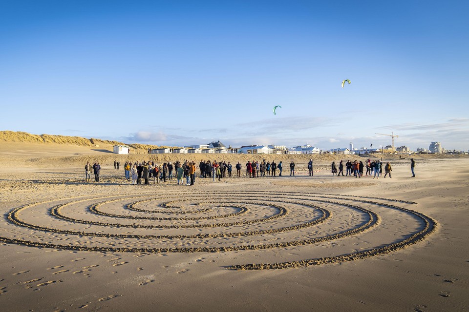 Landschapskunstenaar Gerard ten Broek maakt cirkels op het strand.