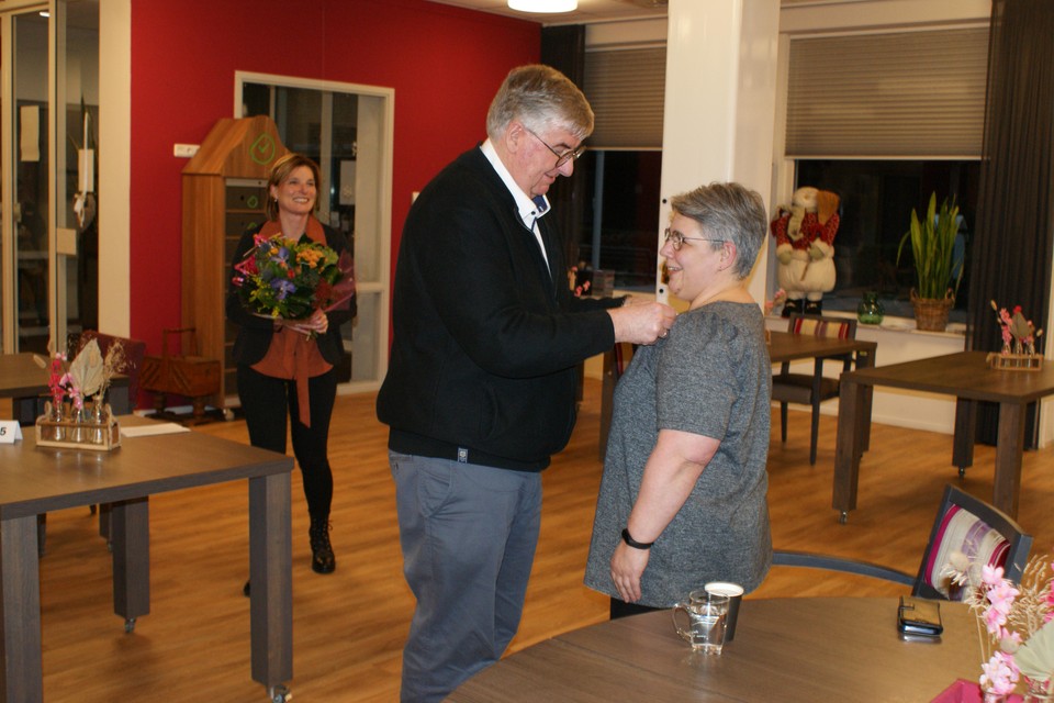 Coby van Popering krijgt de onderscheiding door haar man opgespeld.