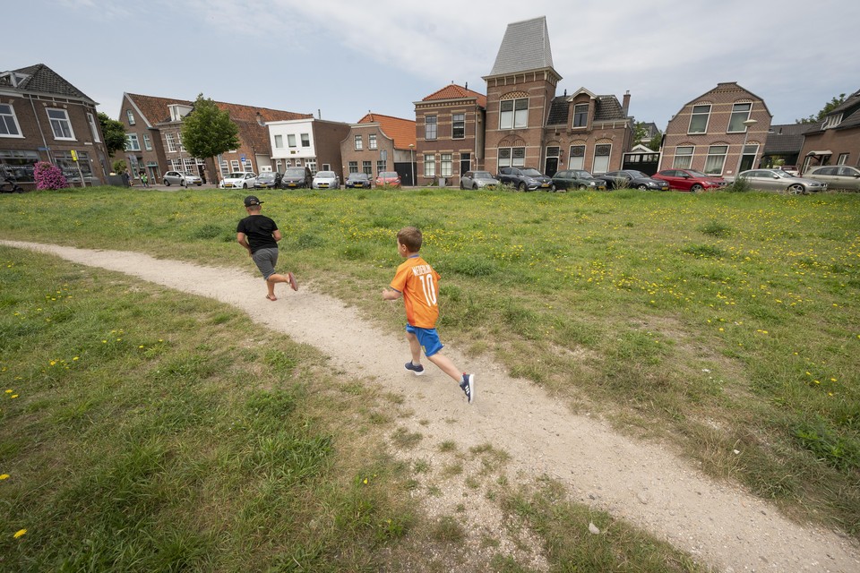 Kinderen spelen op het braakliggende terrein op de hoek van Bronckhorststraat en de Raadhuisstraat.