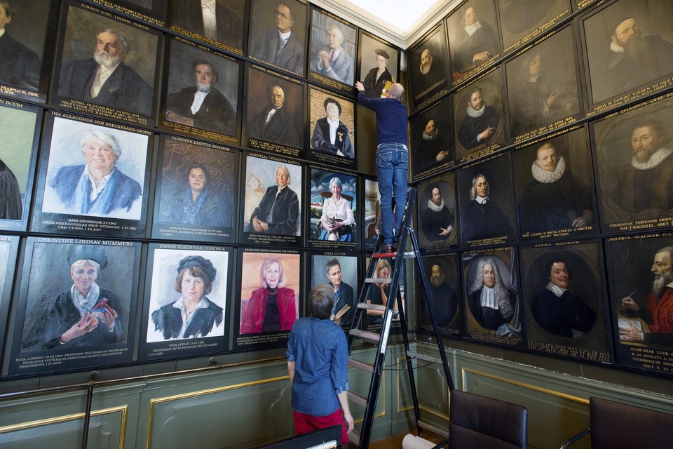 Corrie van Maris (Academisch Historisch Museum) en Willem Otterspeer (universiteitshistoricus van de Universiteit Leiden) hangen de portretten op.