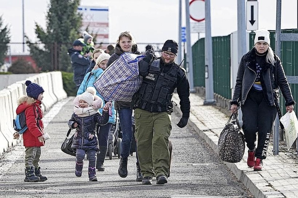 Oekraïense vluchtelingen steken de grens met Polen over.